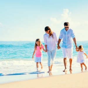 Happy family walking on the beach